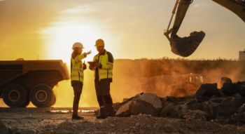 construction workers discussing project plans at a busy worksite